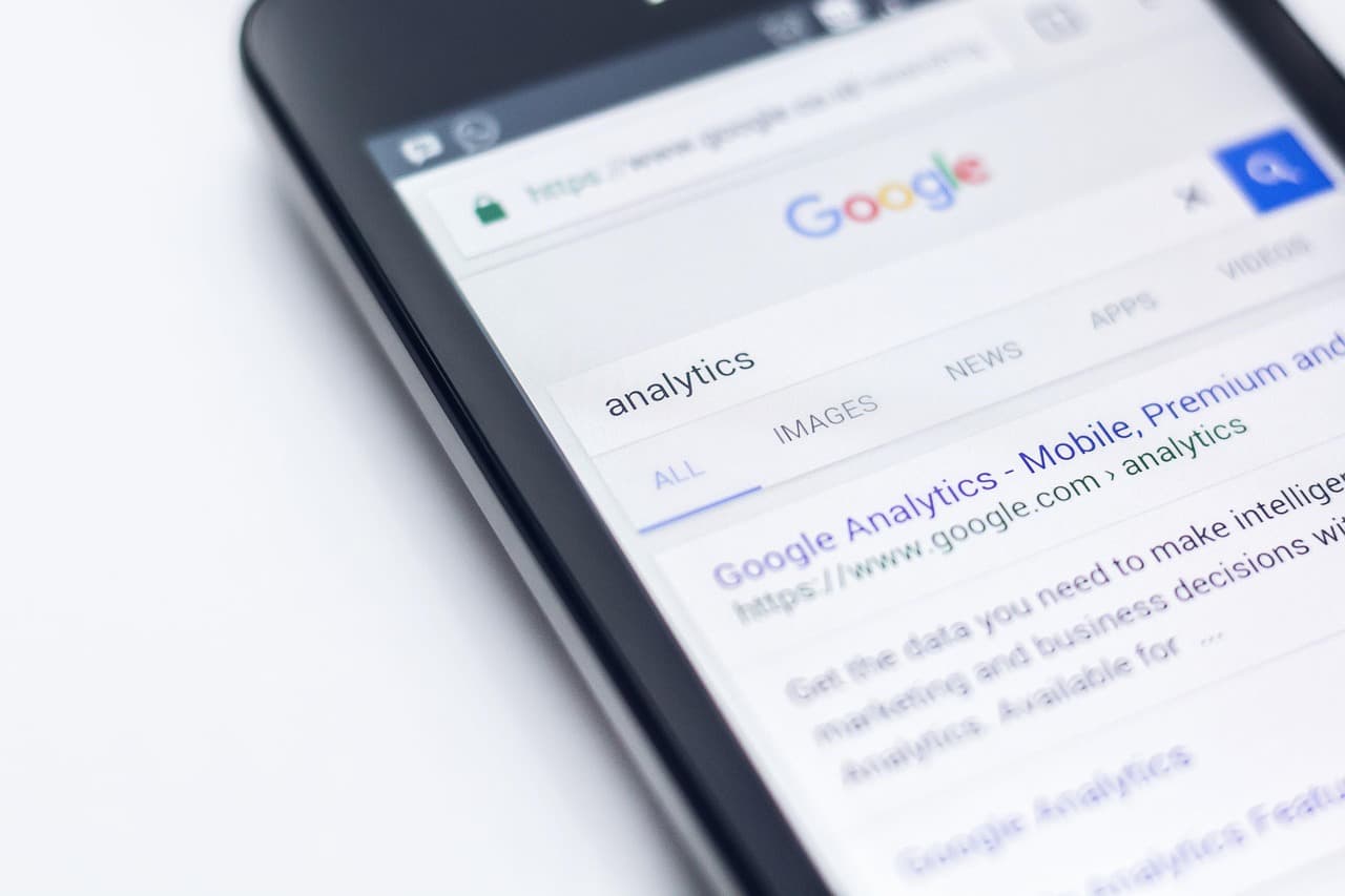 Gros plan sur un smartphone affichant une recherche Google du mot « analytics »