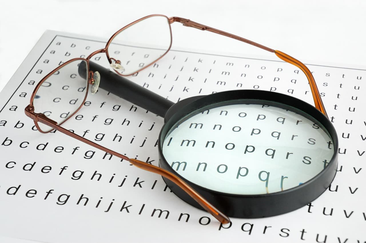 Personne consultant des documents avec une loupe, illustrant la vérification et le contrôle qualité d'un contenu