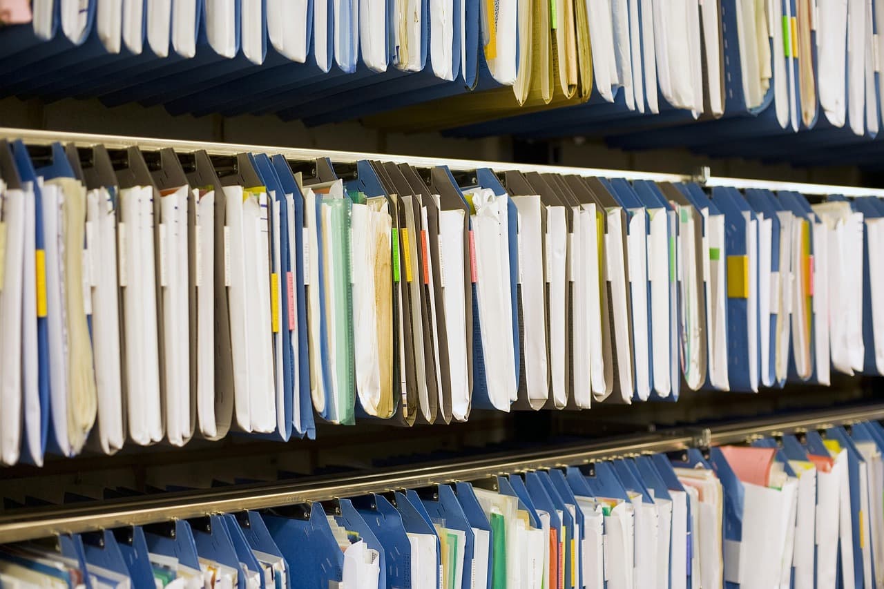 Dossiers de documents et classeurs organisés représentant une base documentaire d'entreprise