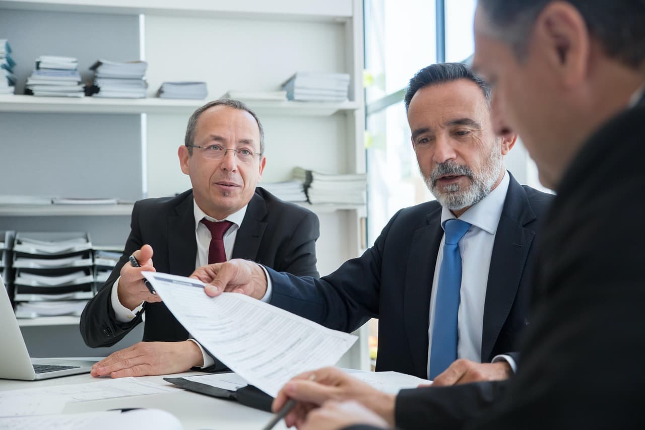 Personnes en réunion autour d'une table de travail, illustrant la gouvernance d'entreprise et la prise de décision