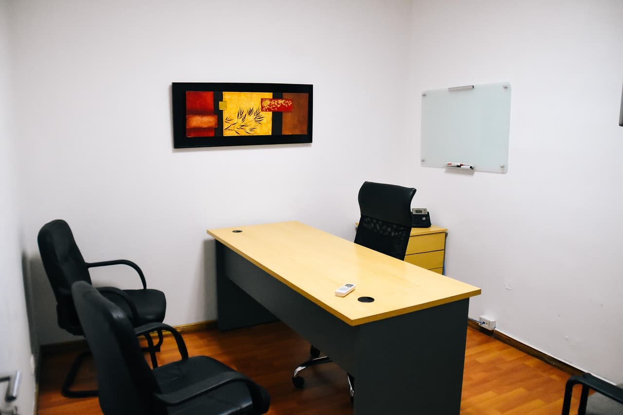 Petit bureau avec chef d'entreprise en réflexion devant un ordinateur portable