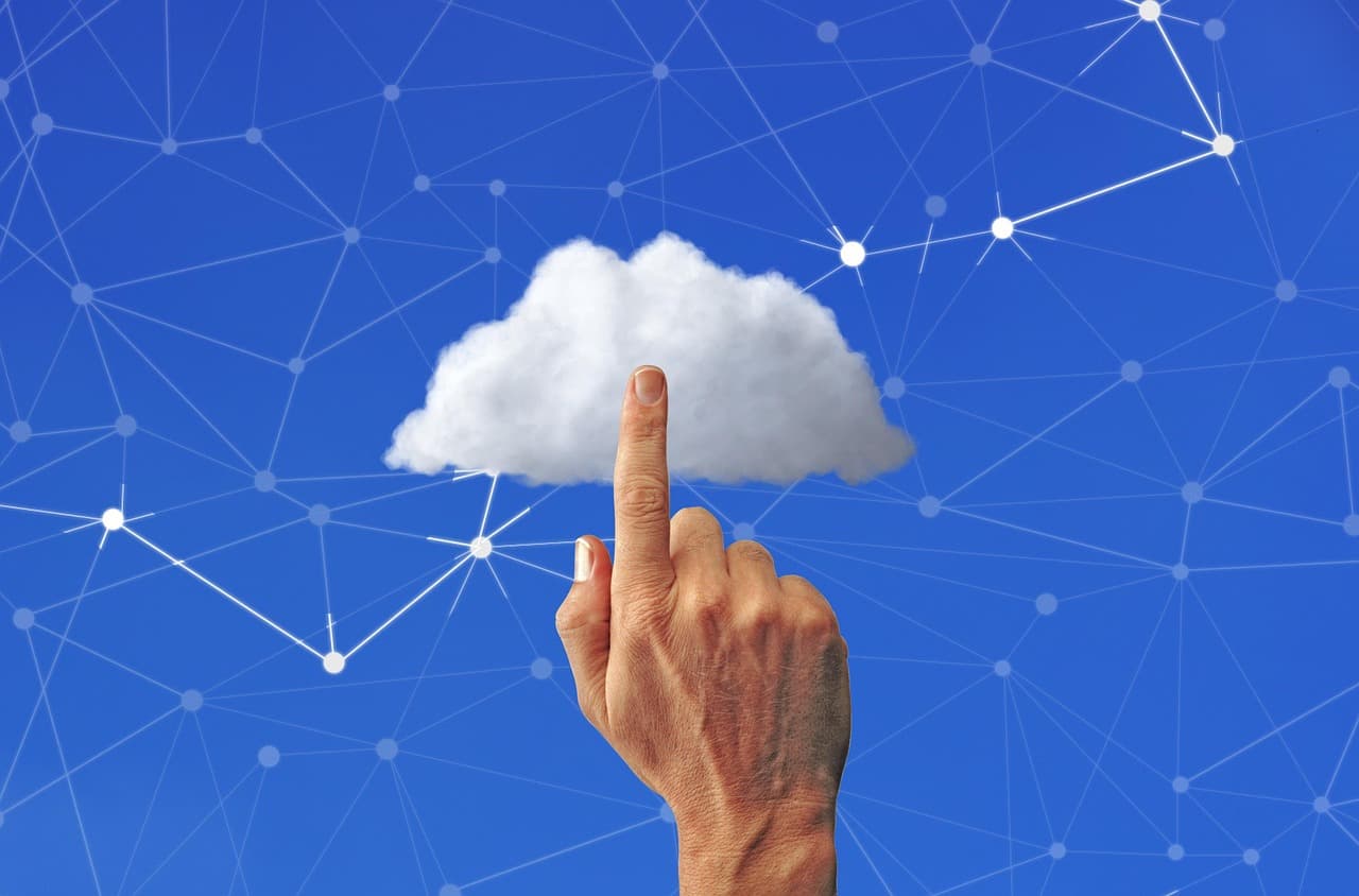 Main touchant une icône de cloud connectée à un réseau de points, symbole de l'architecture API entre back-office et front-end