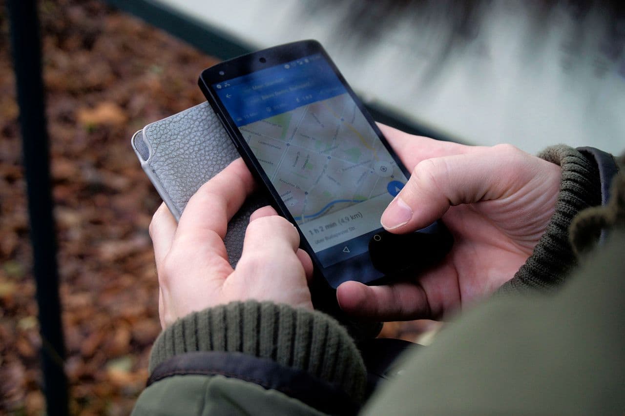Personne consultant un itinéraire Google Maps sur son smartphone en extérieur